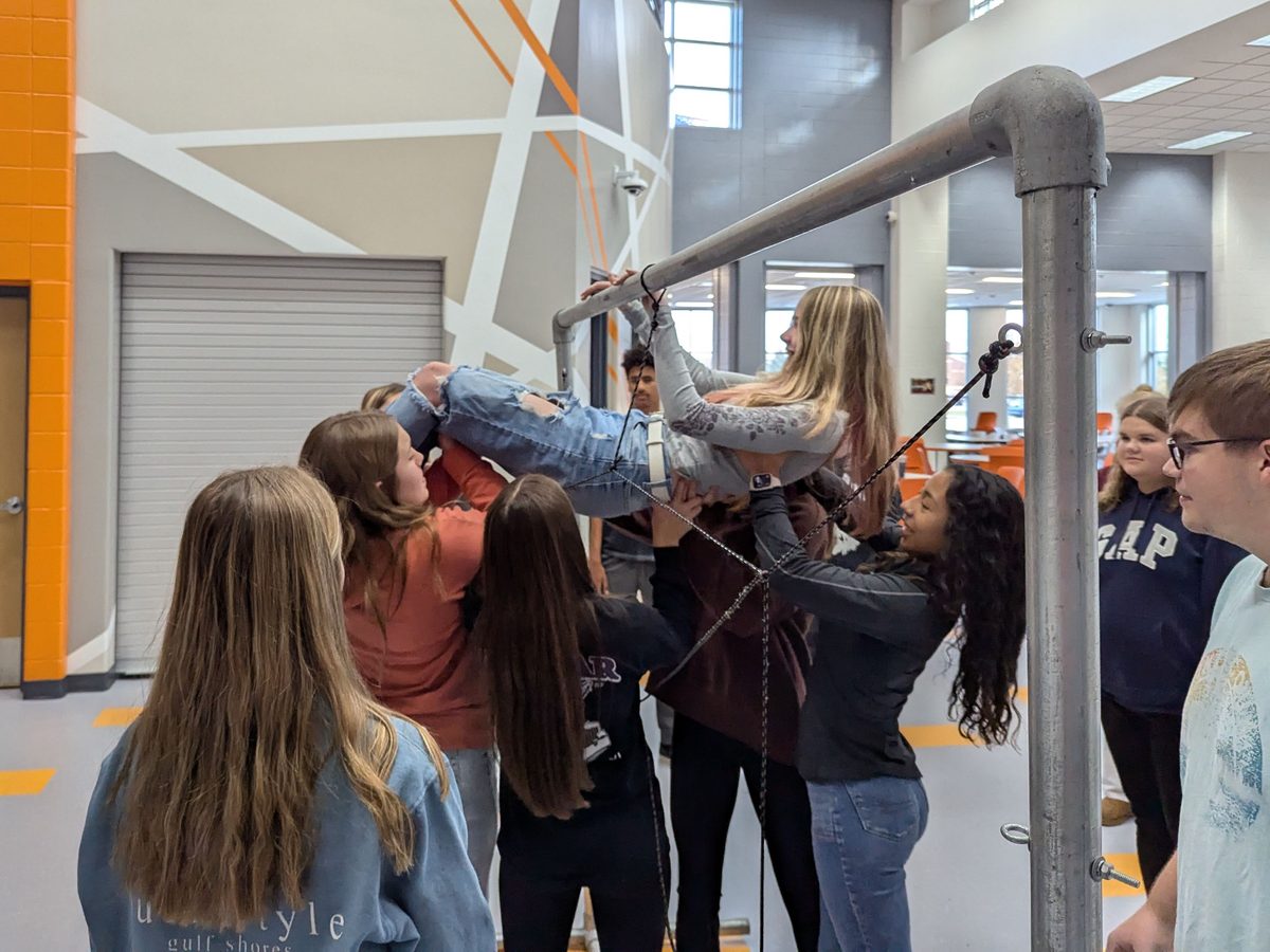 High-school students lifting a classmate together in a GRiT trust exercise
