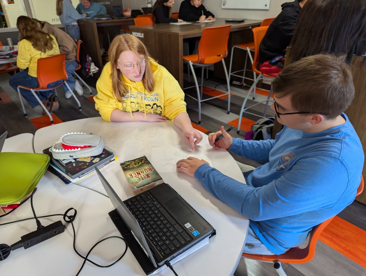 Two students working together at a table